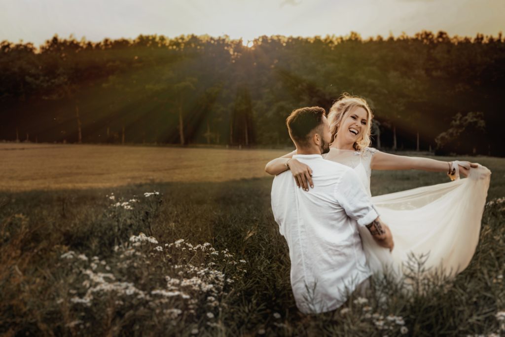 Couple en tenue de mariage dans un champs. Organisation de A à Z. Wedding planner Ile de France. Paris en Noces