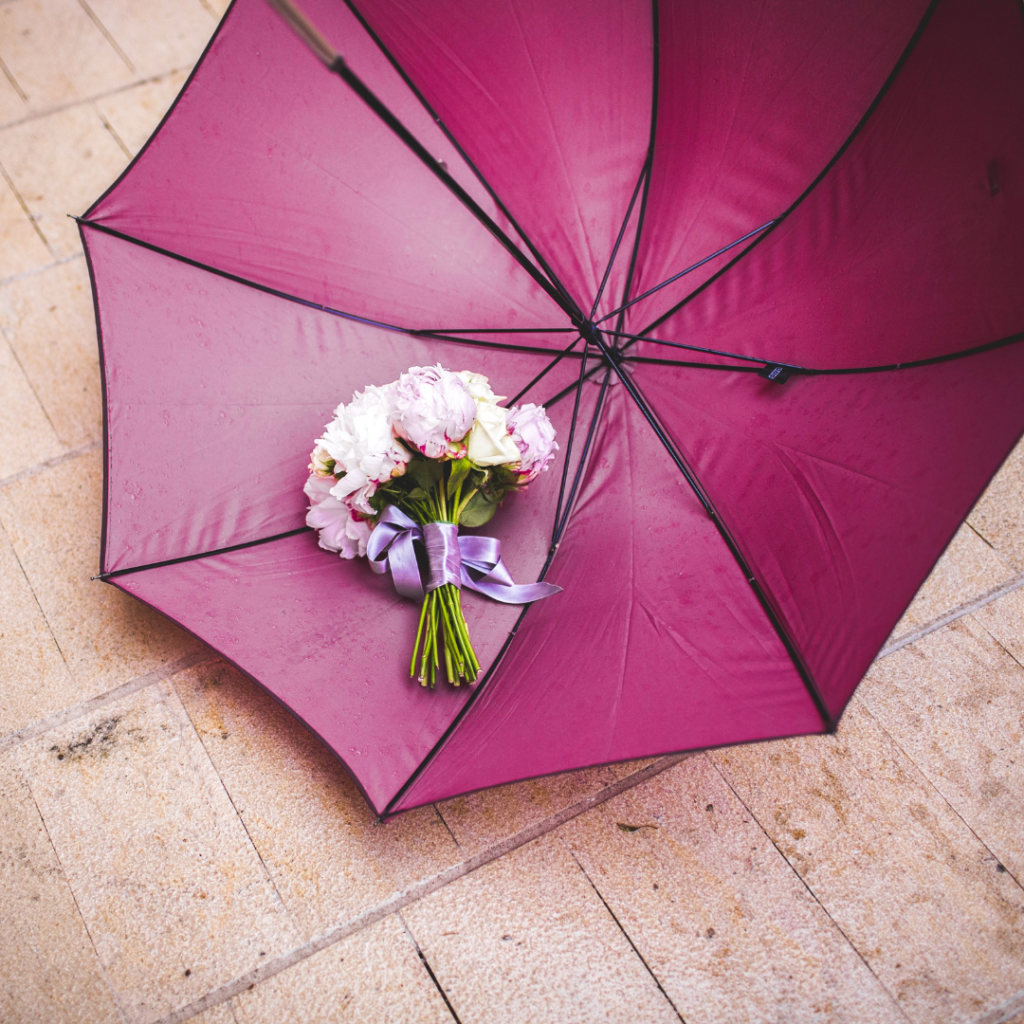 Bouquet dans un parapluie ouvert posé au sol. Mariage pluvieux. Wedding Planner Ile de France. Paris en Noces