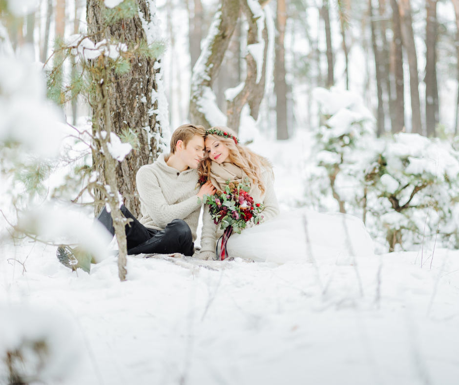 Couple amoureux, assis dans la neige dans la forêt. Mariage d'hiver. Wedding Planner en Ile de France. Paris en Noces 