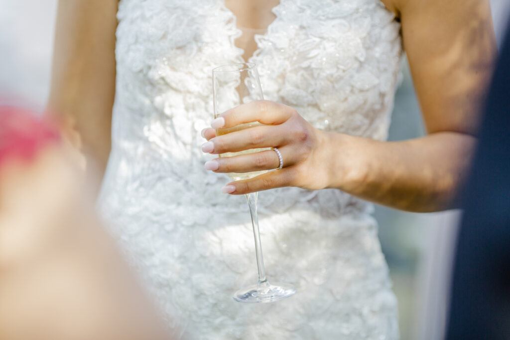 Mariée qui porte un verre de champagne pendant le vin d'honneur. Wedding Planner en Ile de France. Paris en Noces